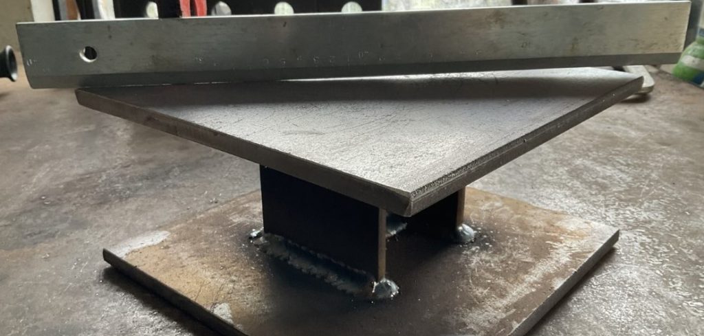 Verzogene Fußplatte durch Schweißverzug – Krümmung sichtbar, thermisches Richten notwendig